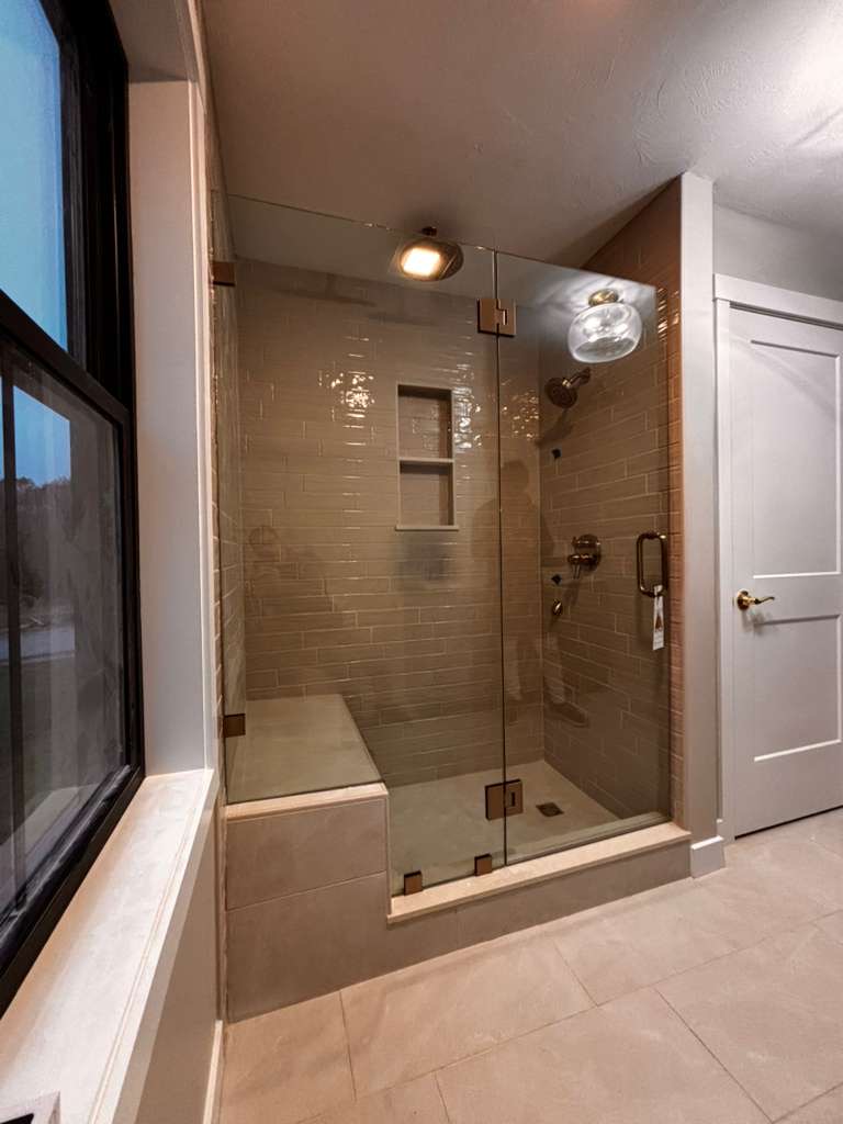 Horus Glassworks custom shower door with bronze hardware