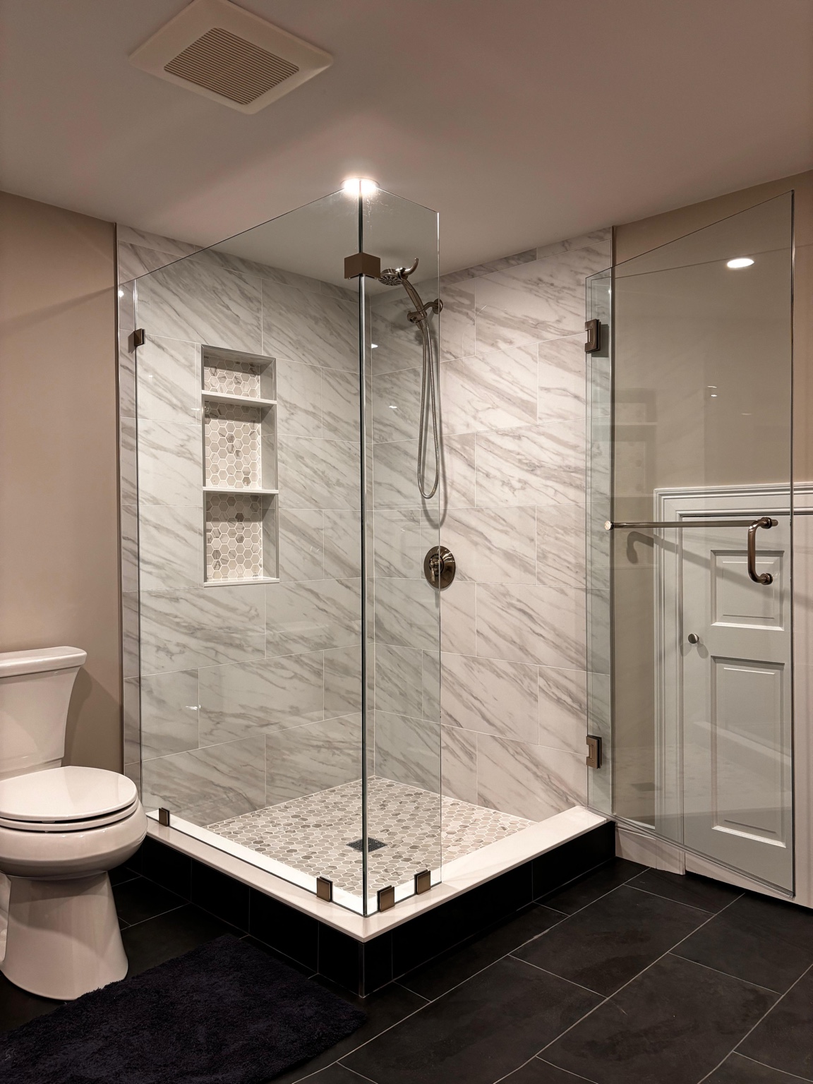 Horus Glassworks frameless corner shower enclosure in a marble bathroom
